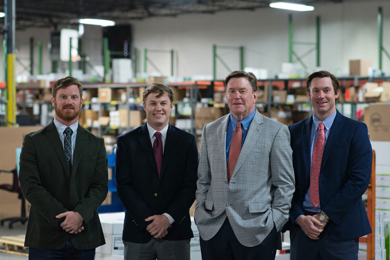 GOS leaders standing in warehouse and shipping facility