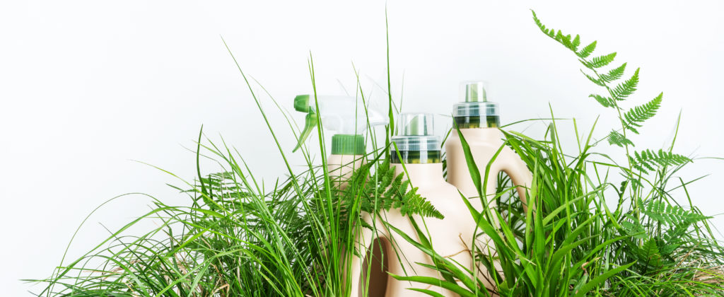 Environmentally friendly janitorial cleaning supplies nested in grass.