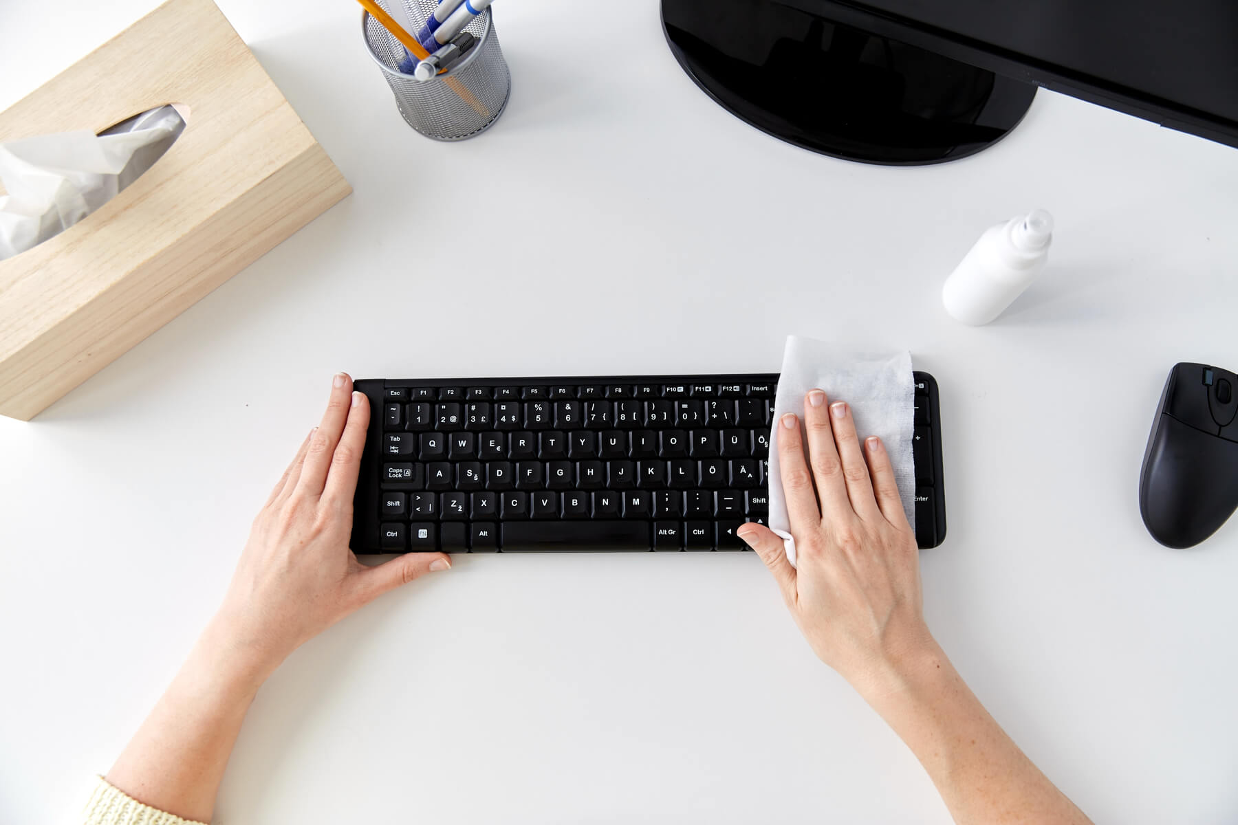 Hands cleaning keyboard with disinfectent wipe